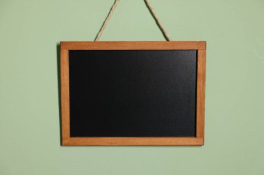 Açık yeşil duvarda boş bir karatahta