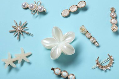 Açık mavi arkaplanda farklı saç tokaları, düz yatış