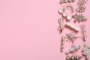 Different hair clips on pink background, flat lay. Space for text