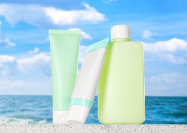 Deniz kıyısındaki mavi gökyüzünün altında güneş kremi ürünleri