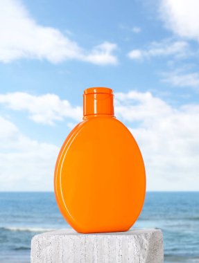 Deniz kenarında bir şişe güneş kremi.