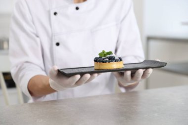 Mutfaktaki gri masada lezzetli tartlı pastacı, yakın plan.