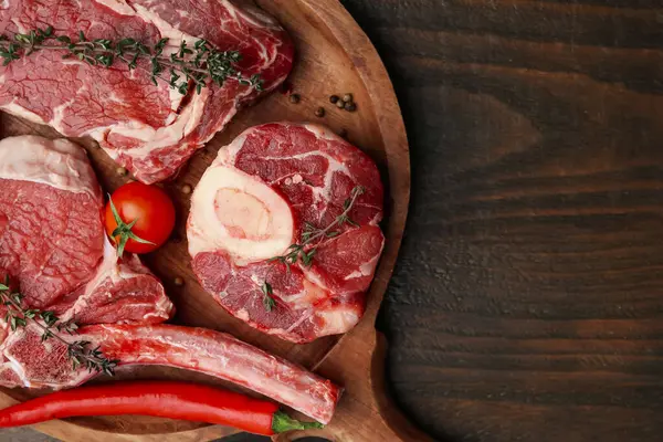Çiğ sığır eti, baharat ve ürünler ahşap masa üzerinde, üst manzara. Metin için boşluk