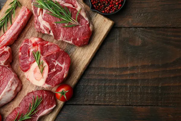 Tahta masada çiğ et, baharat ve domates parçaları. Metin için boşluk