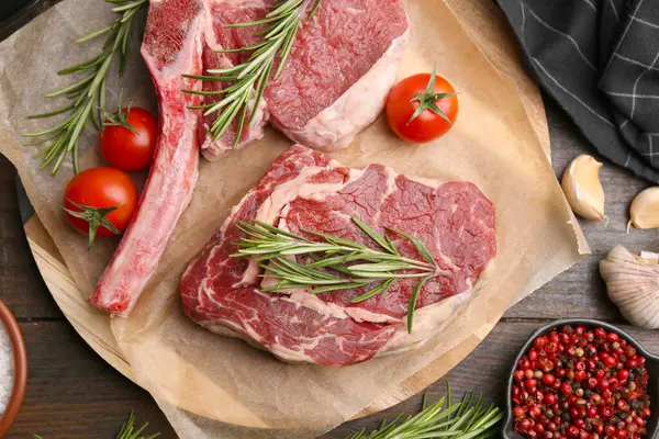 Çiğ et parçaları, ürünler ve baharatlar ahşap masa, düz yatıyordu.