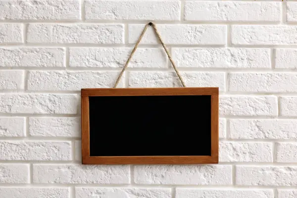 Beyaz tuğla duvarda boş bir karatahta