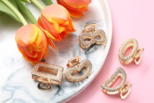 Pembe arka planda güzel saç tokaları ve laleler.