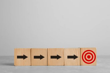 Hedef alınıyor. Beyaz zemin üzerinde hedef tahtası olan oklu küpler.