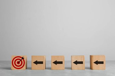 Hedef alınıyor. Beyaz zemin üzerinde hedef tahtası olan oklu küpler.