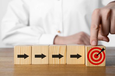 Hedef alınıyor. Diğer okları ahşap masaya koyan kadınların yanına küpü yerleştiriyor, yakın plan.