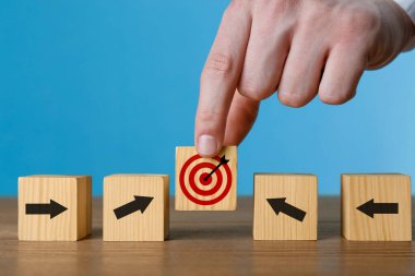 Hedef alınıyor. Diğer okları ahşap masaya koyan adam küpü tam ortaya koyuyor.