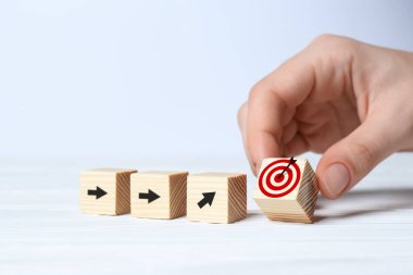 Hedef alınıyor. Arkaplanda okları olan kadınların yanına küpü yerleştiriyor, yakın plan.