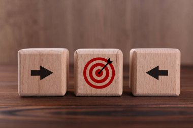 Hedef alınıyor. Elinde oklar olan küpler tahtada hedef tahtası.