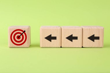 Hedef alınıyor. Açık yeşil zemin üzerinde hedef tahtası olan oklu küpler.