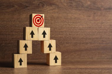 Hedef alınıyor. Küplerin piramidi, üzerinde oklar olan tahtadan arkaplanı hedef alan bir piramit.