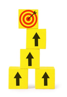 Hedef alınıyor. Yığılmış küplerin üzerinde beyaz arka planda hedef tahtası olan oklar var.