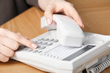 Ahşap masada telefonla arayan kadın, yakın plan.