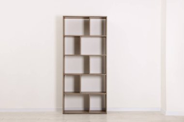 Beyaz duvarın yanındaki boş ahşap raf ünitesi.