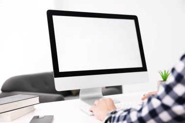 Ofisteki beyaz masada bilgisayarda çalışan bir adam, yakın plan. Tasarım için model