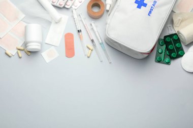 Gri arkaplan üzerinde ilk yardım çantasıyla düz konum, metin için boşluk