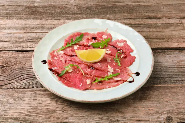 Tahta masada roka, peynir, balzamik sirke ve limon ile nefis sığır eti carpaccio.