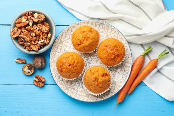 Lezzetli havuçlu kekler, cevizler ve taze sebzeler açık mavi ahşap masa, düz uzanmış