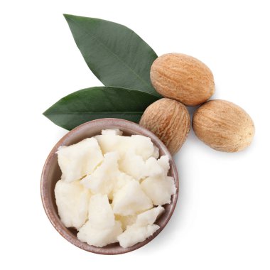 Doğal tereyağı kasede, fındık ve yeşil yapraklar beyaza izole edilmiş, üst manzara.