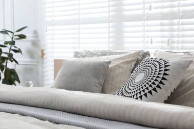 Şık bir odada yumuşak çarşafları olan rahat bir yatak, yakın çekim. İç tasarım