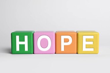 Açık gri arkaplanda renkli küplerden oluşan Umut kelimesi