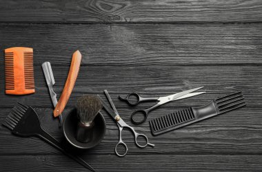 Siyah ahşap masa üzerinde birçok farklı berber aletleri, düz yatıyordu. Metin için boşluk