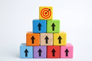 Hedef alınıyor. Renkli küplerin piramidi, beyaz arkaplan üzerinde hedef tahtası olan oklar.