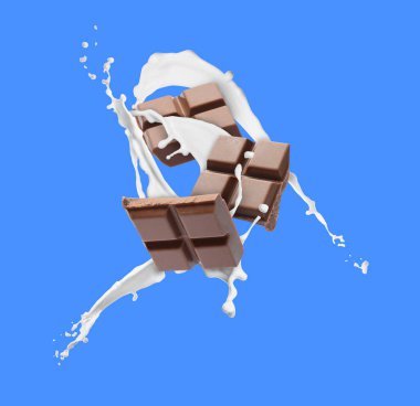 Lezzetli çikolata parçaları ve mavi arka planda havadaki süt damlaları.