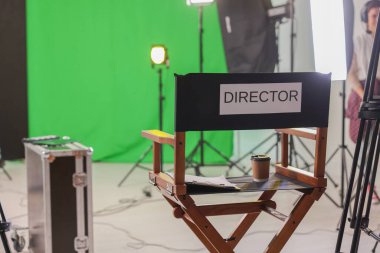 Modern film stüdyosunda çalışan kişi, kelime yönetmeniyle sandalyeye odaklan.