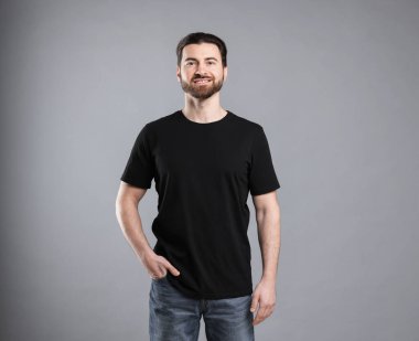 Açık gri arka planda siyah tişört giyen bir adam. Tasarım için model