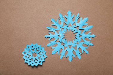 Kahverengi arka planda güzel kar taneleri, düz uzanmış.