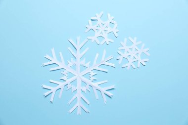 Açık mavi zemin üzerinde güzel kar taneleri, düz uzanmış.