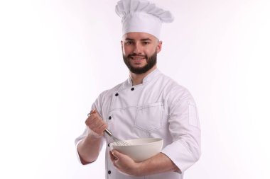 Üniformalı mutlu pastacı elinde çırpı ve kase ile beyaz arka planda