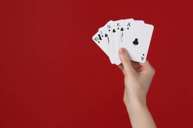 Kırmızı arka planda iskambil oynayan kadın, yakın plan. Metin için boşluk