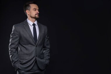 Siyah arka planda klasik takım elbiseli kendine güvenen bir adam. Metin için boşluk