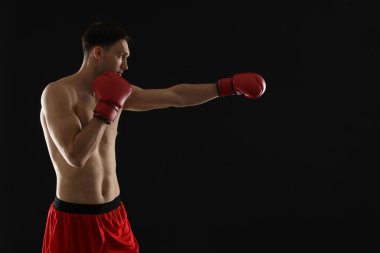 Siyah arka planda dövüşen boks eldivenli adam, metin için boşluk