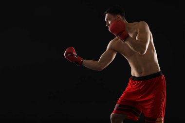 Siyah arka planda dövüşen boks eldivenli adam, metin için boşluk