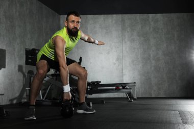 Spor salonunda kettlebell ile atletik adam eğitimi. Metin için boşluk