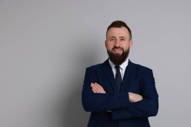 Gri arka planda takım elbiseli yakışıklı sakallı adam. Metin için boşluk