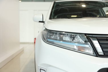 New modern white car in salon, closeup. Space for text
