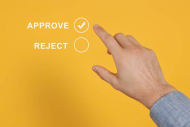 Adam turuncu arkaplan ile sanal ekranda Onaylamayı seçiyor, yakın plan