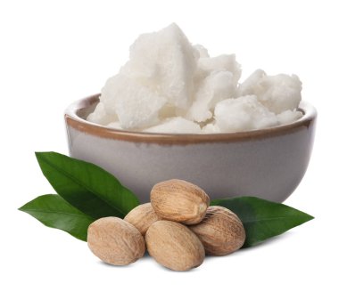 Kase içinde doğal Shea yağı, fındık ve yeşil yapraklar beyaz üzerine izole