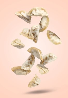 Pek çok pişmemiş gyoza pembe arka plana düşüyor