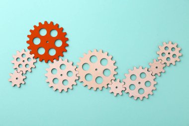 Farklılık, eşsizlik, bireysellik. Açık mavi zemin üzerinde ahşap olanlar arasında kırmızı çark, üst görünüm