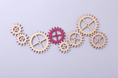 Farklılık, eşsizlik, bireysellik. Gri arka planda, ahşap olanlar arasında pembe çark, üst manzara.