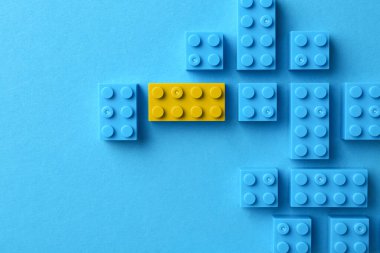 Farklılık, eşsizlik, bireysellik. Renk arkaplanı, üst görünümü mavi olanlar arasında sarı yapı bloğu